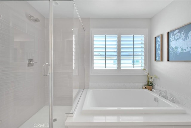 bathroom featuring a garden tub and a shower stall