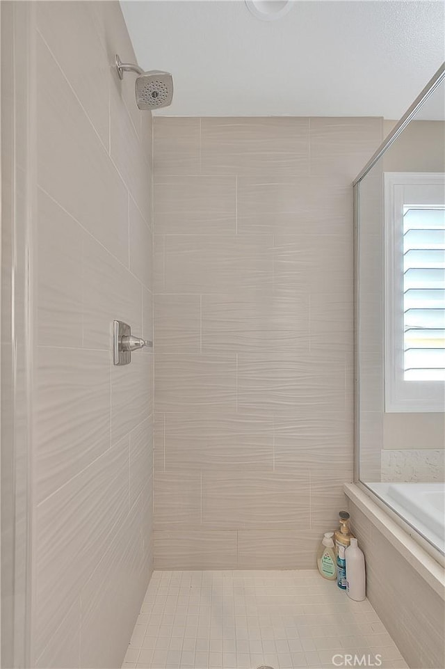 full bathroom featuring tiled shower and a tub to relax in