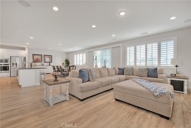 living area featuring recessed lighting, visible vents, and light wood finished floors