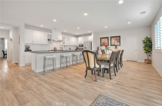 dining room with light wood finished floors, visible vents, recessed lighting, and baseboards