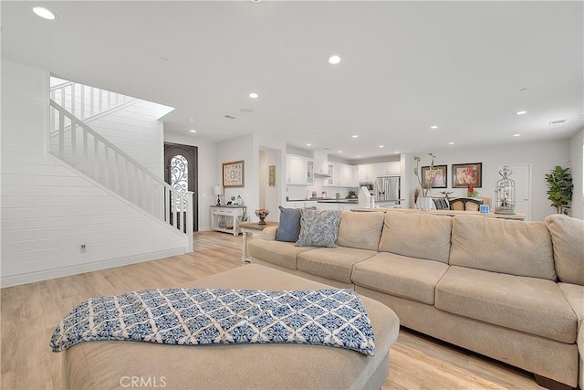 living room with recessed lighting, stairs, and light wood finished floors