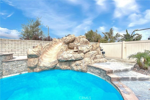 view of swimming pool featuring fence