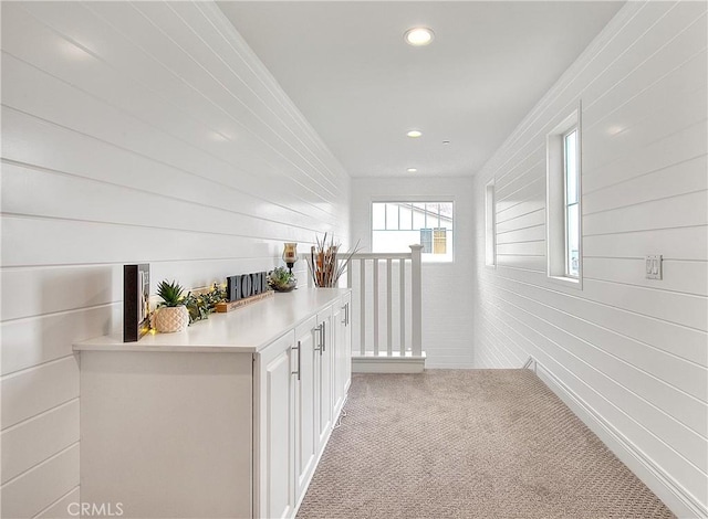 hall featuring an upstairs landing, recessed lighting, and carpet