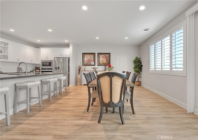 dining space featuring recessed lighting, light wood-style floors, and baseboards