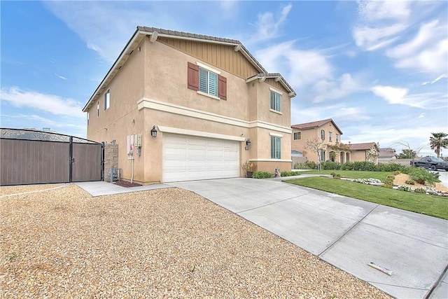 traditional-style house with an outbuilding, a front yard, an attached garage, stucco siding, and concrete driveway