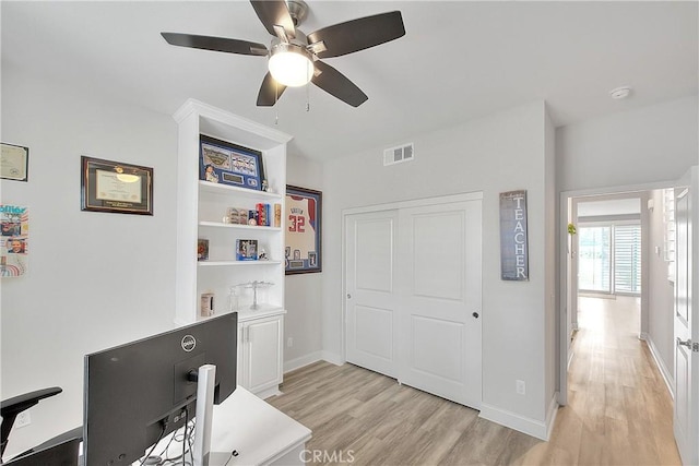 office area featuring baseboards, a ceiling fan, visible vents, and light wood-type flooring