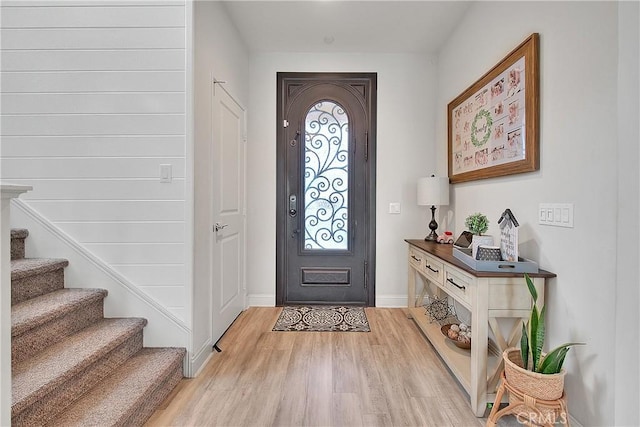 entryway featuring stairs, light wood-style flooring, and baseboards