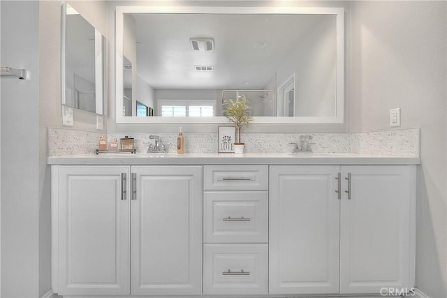 bathroom featuring a sink, visible vents, and double vanity