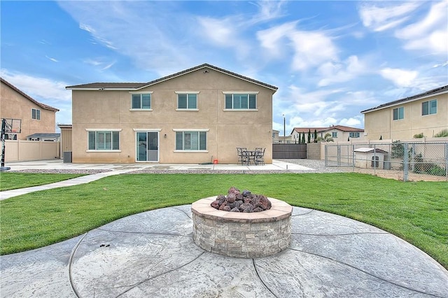 back of property featuring stucco siding, a lawn, a fenced backyard, and a patio area