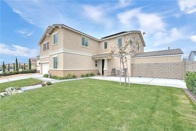 traditional-style house with solar panels, a front lawn, fence, and stucco siding