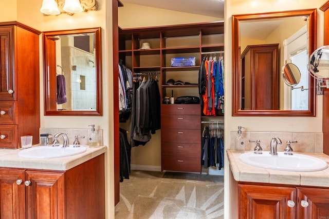 bathroom featuring vaulted ceiling, two vanities, and a sink