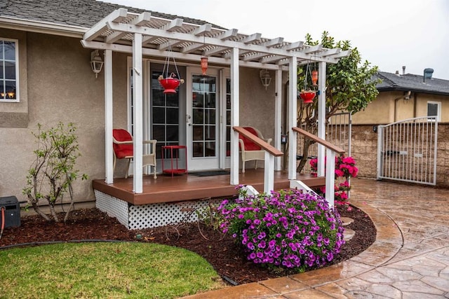 entrance to property with stucco siding, roof with shingles, and a pergola