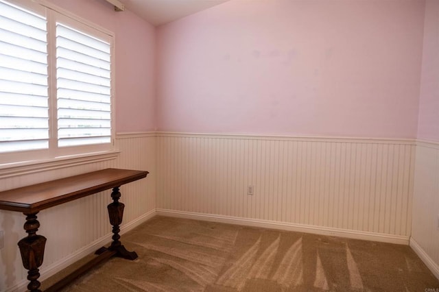 carpeted empty room with wainscoting