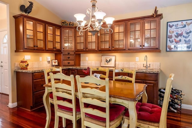 dining area with dark wood-style floors, baseboards, and a chandelier