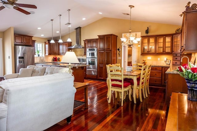 dining room with visible vents, ceiling fan with notable chandelier, dark wood finished floors, recessed lighting, and vaulted ceiling