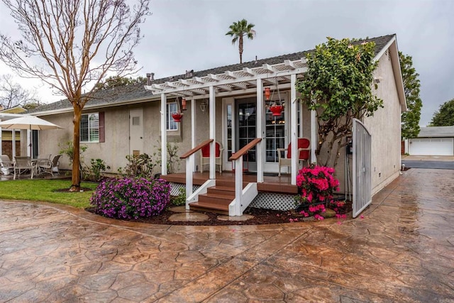 ranch-style house with stucco siding, a patio, and a pergola