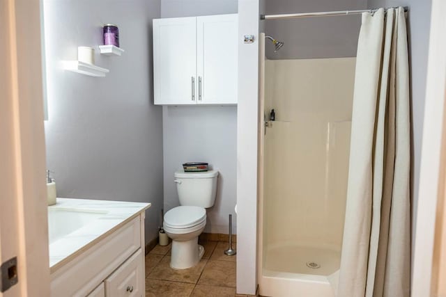 bathroom with tile patterned floors, toilet, a stall shower, and vanity