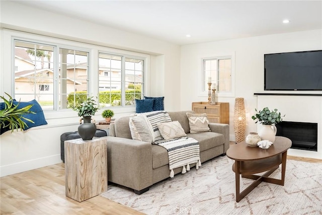 living area with recessed lighting, light wood-type flooring, and baseboards