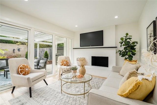 living room featuring recessed lighting, a fireplace, and wood finished floors