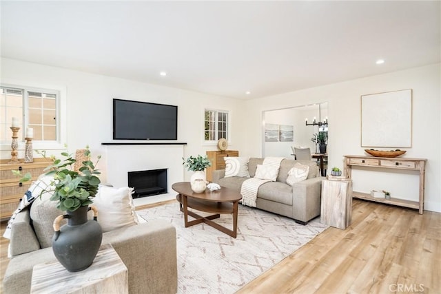 living area featuring a notable chandelier, recessed lighting, and light wood-type flooring