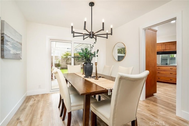 dining room with a healthy amount of sunlight, light wood-style floors, and an inviting chandelier