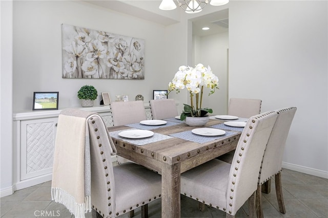 dining room featuring light tile patterned flooring, baseboards, and an inviting chandelier