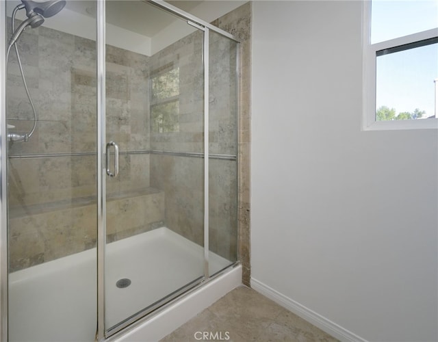 bathroom featuring baseboards and a shower stall