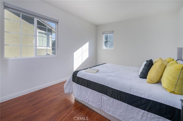 bedroom with wood finished floors and baseboards