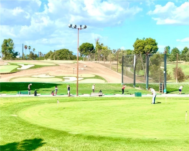 view of community with fence and view of golf course