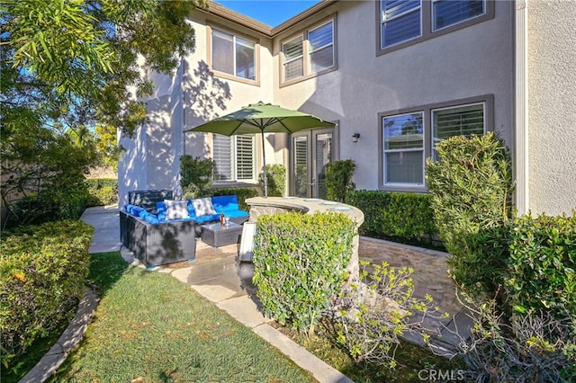 exterior space with a patio area, stucco siding, and outdoor lounge area