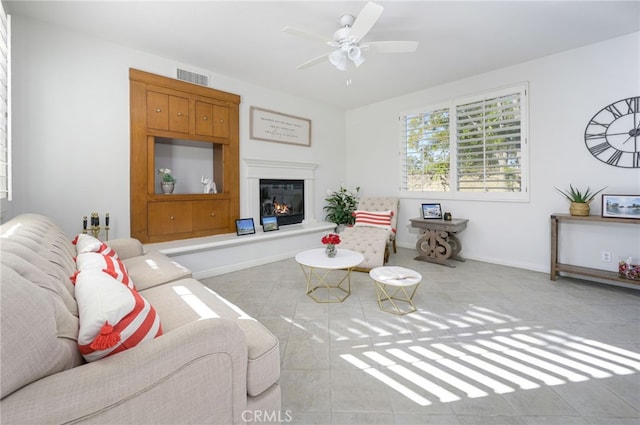 14053 Highlander Rd, La Mirada, CA 90638 - living room with a glass covered fireplace, ceiling fan, tile patterned flooring, and baseboards