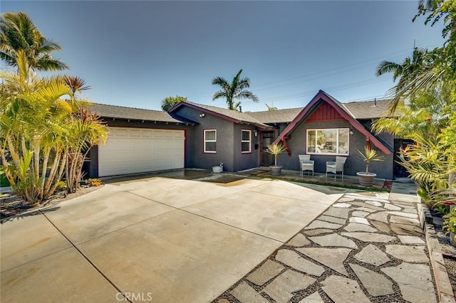 view of front facade featuring a garage, driveway, and stucco siding