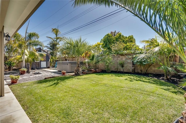 view of yard with a patio area, a hot tub, and a fenced backyard