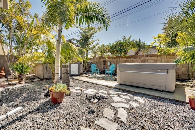 view of yard featuring a patio, a fenced backyard, and a hot tub