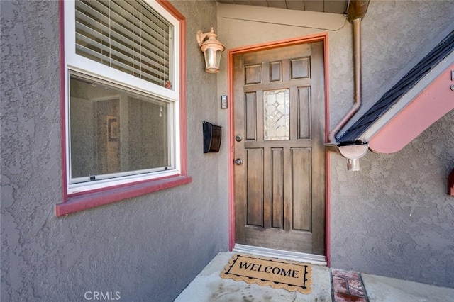 doorway to property featuring stucco siding