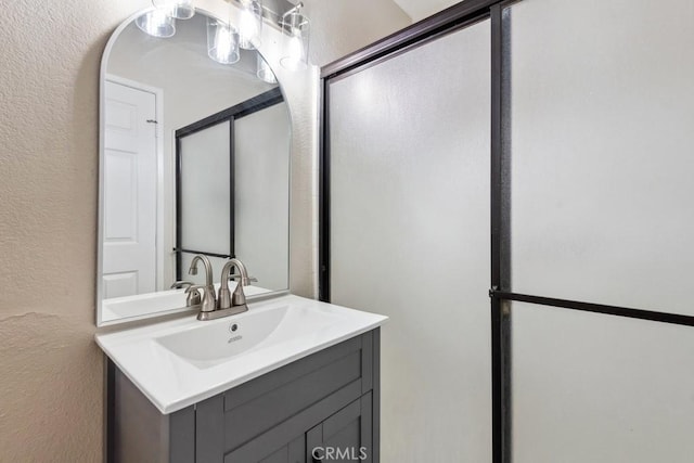 bathroom featuring vanity and a textured wall