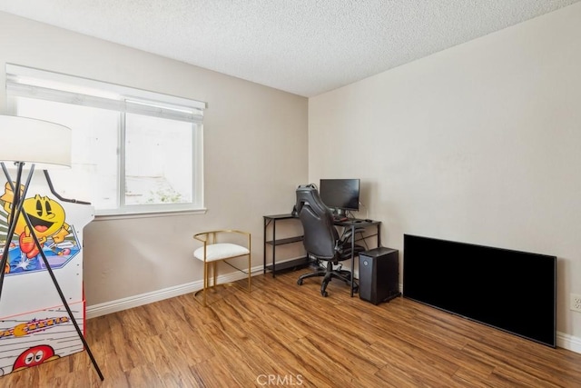 office with wood finished floors, baseboards, and a textured ceiling