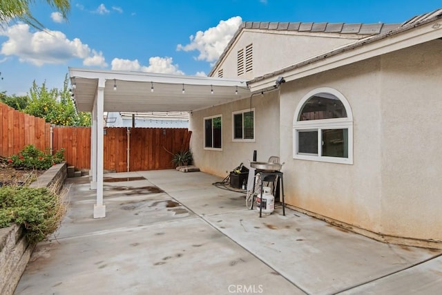 view of patio / terrace with an attached carport and a fenced backyard