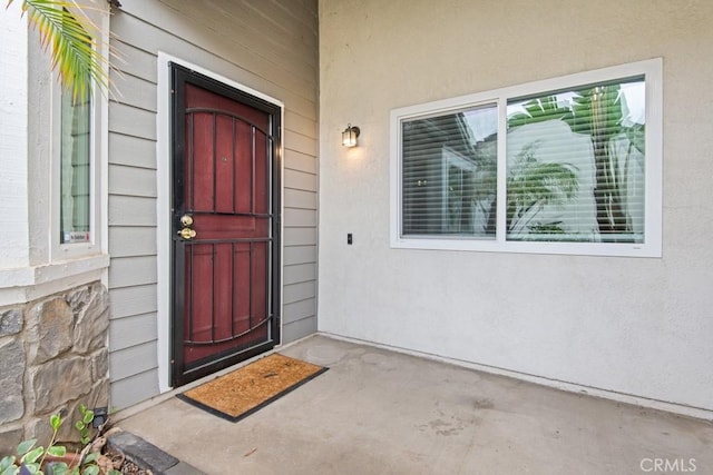 entrance to property featuring stucco siding