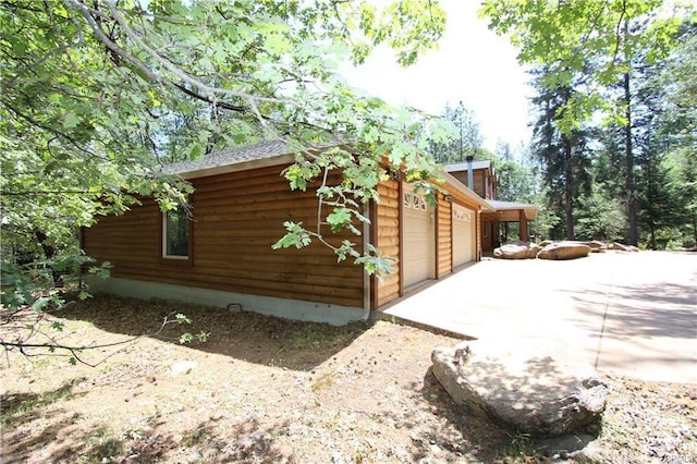 view of side of property with a garage and driveway