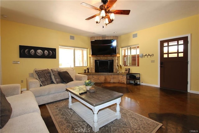 tiled living area featuring visible vents, a fireplace, baseboards, and a ceiling fan