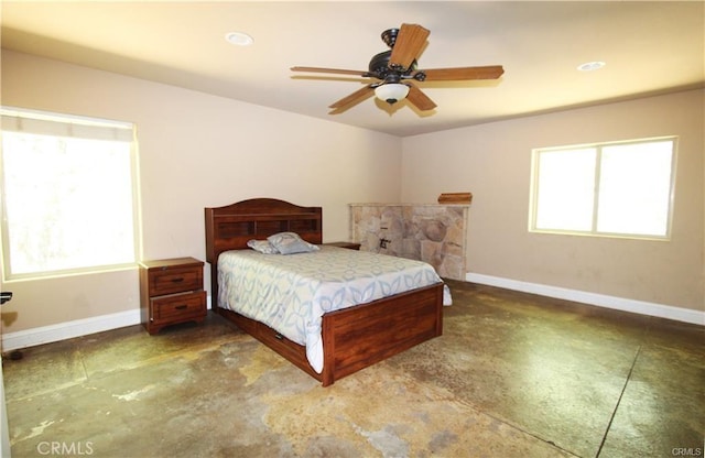 bedroom featuring multiple windows, concrete floors, and baseboards