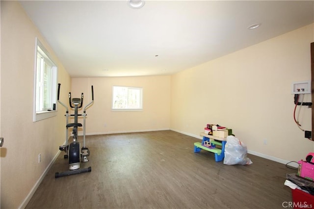 workout room featuring baseboards and wood finished floors