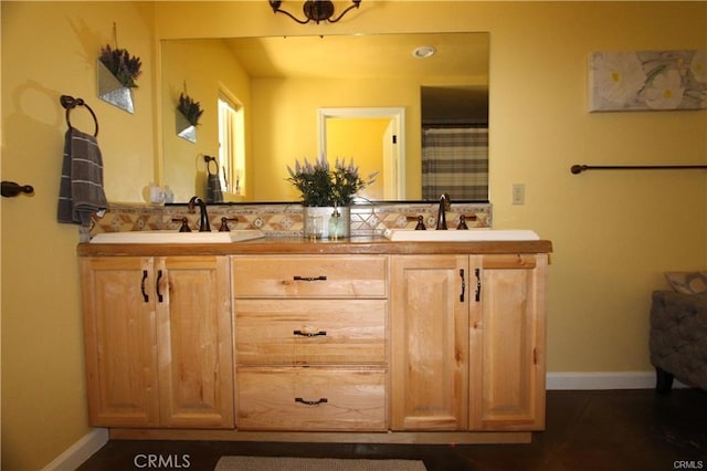 bathroom featuring double vanity, baseboards, and a sink