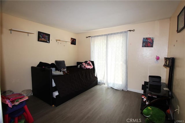 bedroom featuring baseboards and wood finished floors