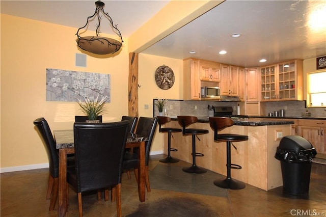 dining area with indoor wet bar, visible vents, recessed lighting, and baseboards