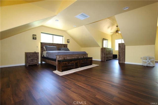 bedroom with dark wood-style floors, visible vents, baseboards, and lofted ceiling