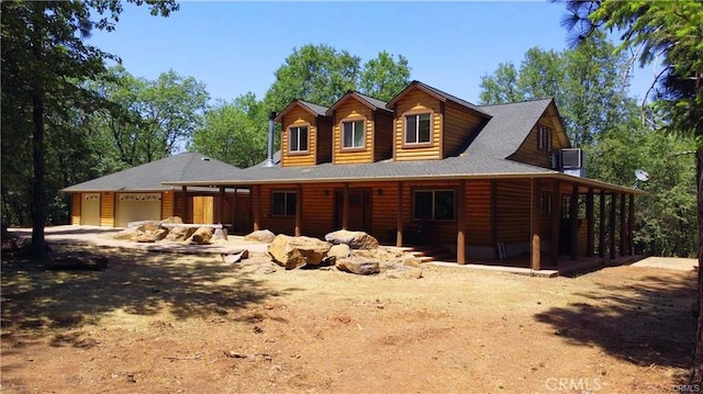 view of front of home featuring an attached garage and faux log siding