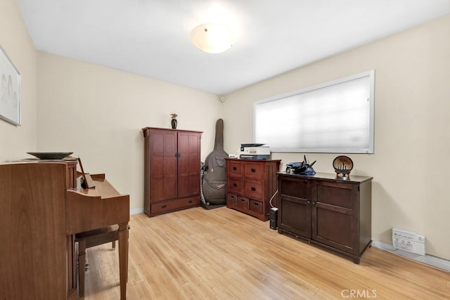 office area featuring light wood-style flooring and baseboards