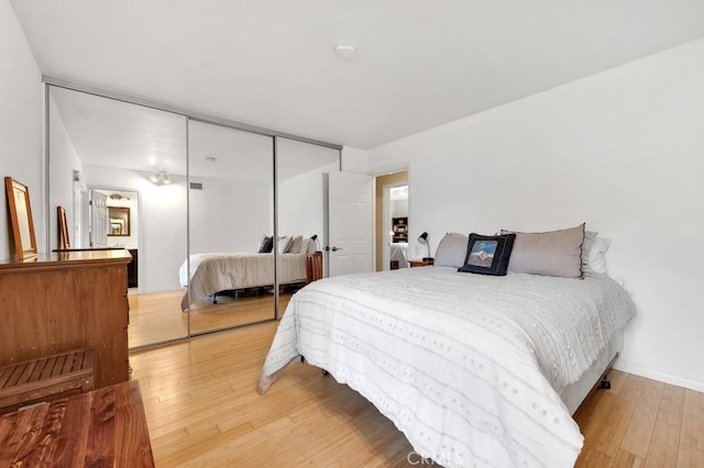 bedroom with a closet, baseboards, and wood-type flooring